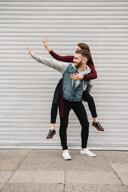 Pareja joven divirtiéndose enfrente de garaje