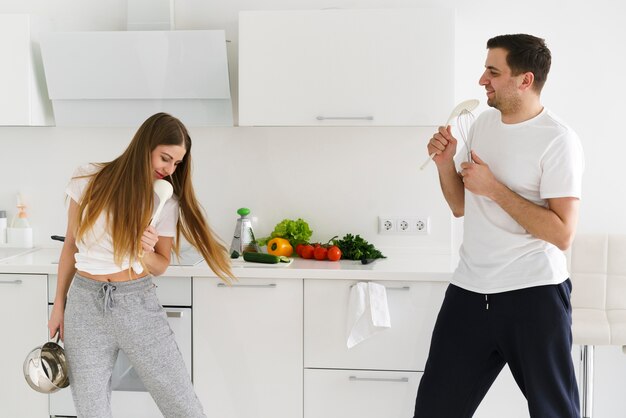 Pareja joven divirtiéndose mientras cocina