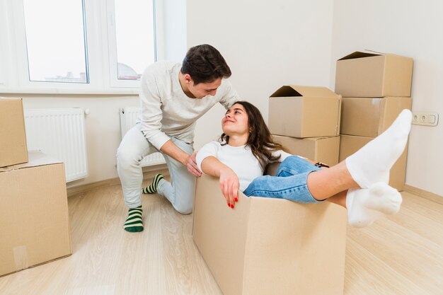 Pareja joven divirtiéndose mientras se muda a un nuevo apartamento