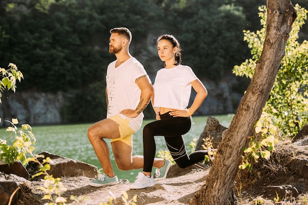 Foto gratuita pareja joven divirtiéndose en la orilla del río en un día soleado