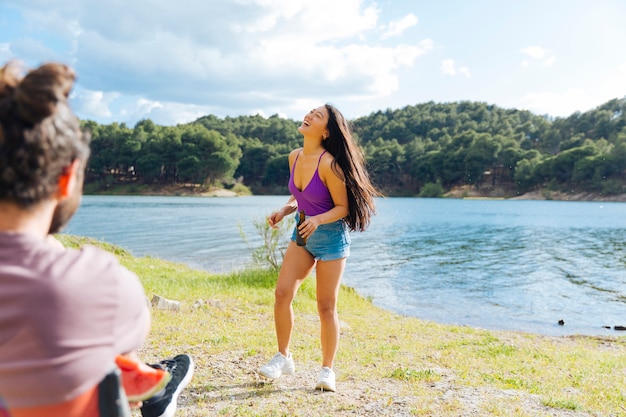 Pareja joven divirtiéndose en la orilla del río