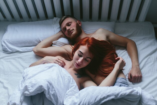 Pareja joven durmiendo en la cama