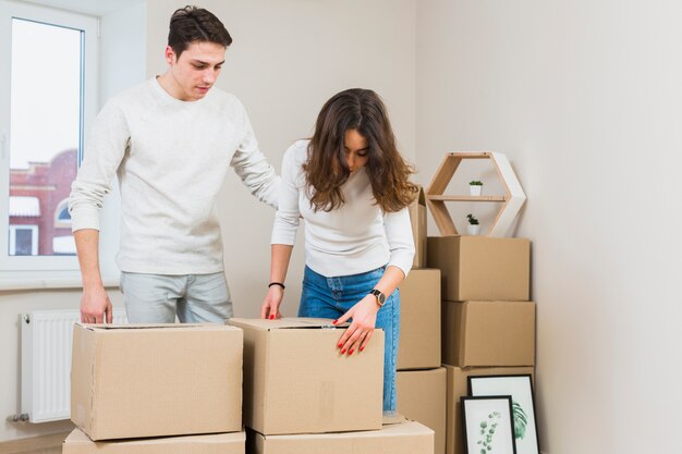 Pareja joven empacando las cajas de cartón en casa