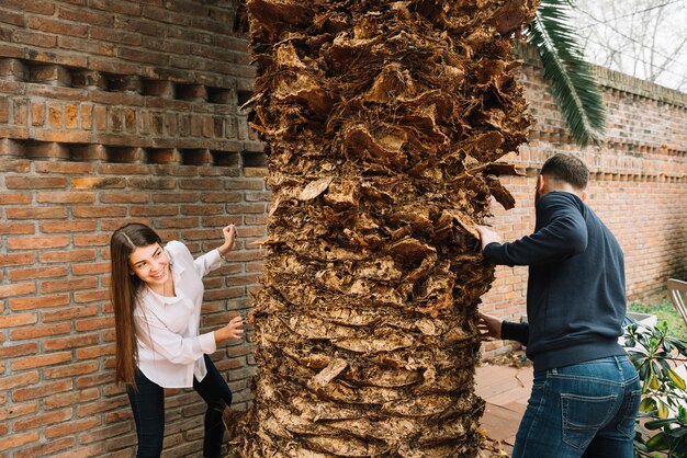 Pareja joven enamorada alrededor de árbol