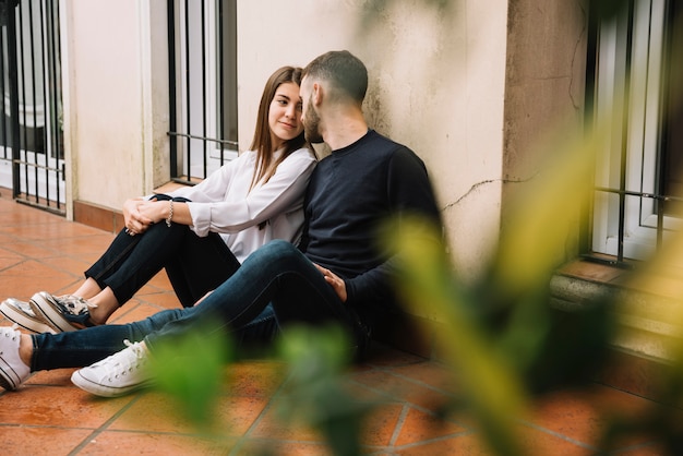 Pareja joven enamorada empujada contra casa