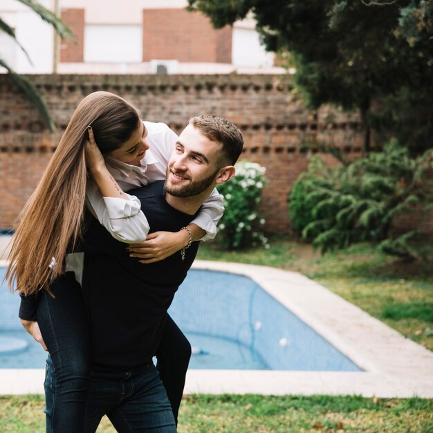 Pareja joven enamorada enfrente de piscina