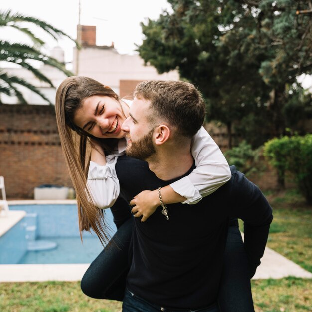 Pareja joven enamorada enfrente de piscina