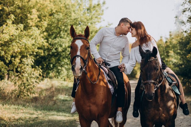 Pareja joven, equitación, caballos, juntos, en el estacionamiento