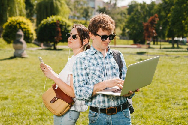 Pareja joven espalda con espalda en la naturaleza