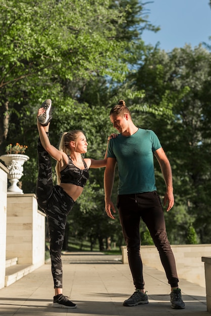 Foto gratuita pareja joven estirando en el parque