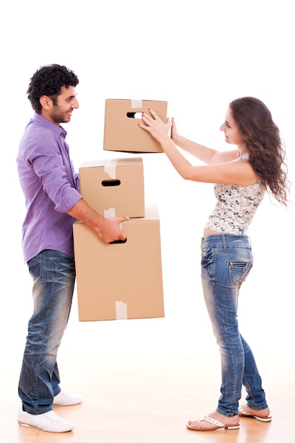 Pareja joven y feliz lleva cajas