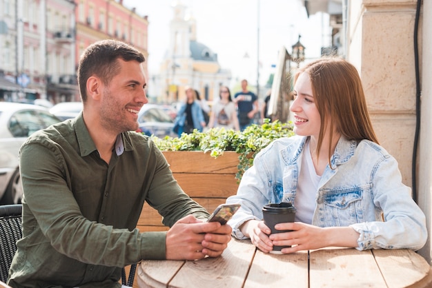 Pareja joven feliz teniendo una cita romántica en caf�