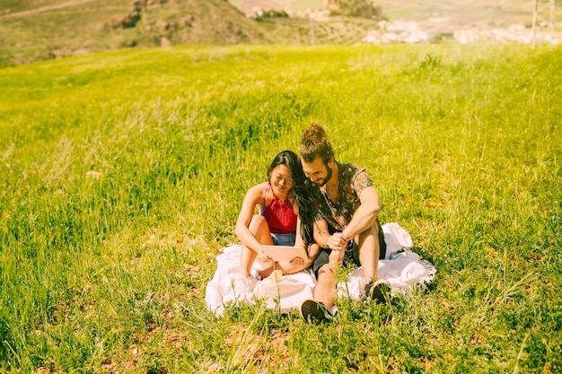 Pareja joven feliz usando tableta en claro