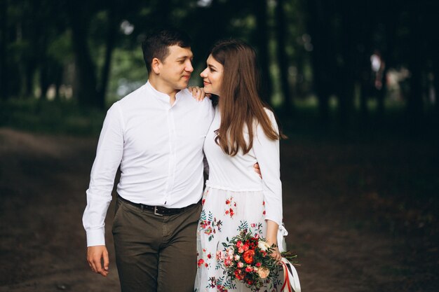 Pareja joven con flores en el parque