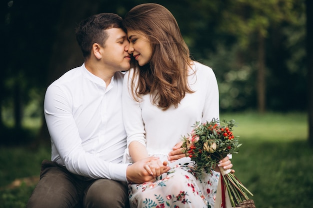 Pareja joven con flores en el parque