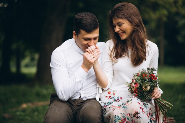 Pareja joven con flores en el parque