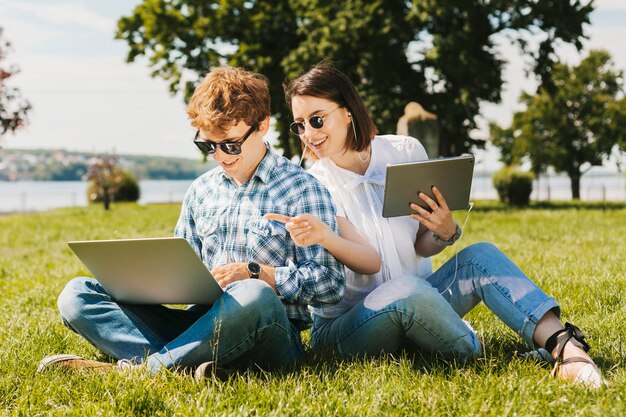 Pareja joven freelance trabajando en el parque.