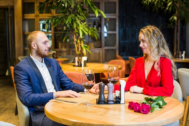 Pareja joven hablando en la mesa en el restaurante