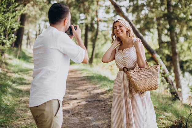 Pareja joven haciendo fotos en el bosque