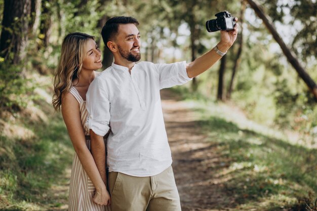 Pareja joven haciendo fotos en el bosque