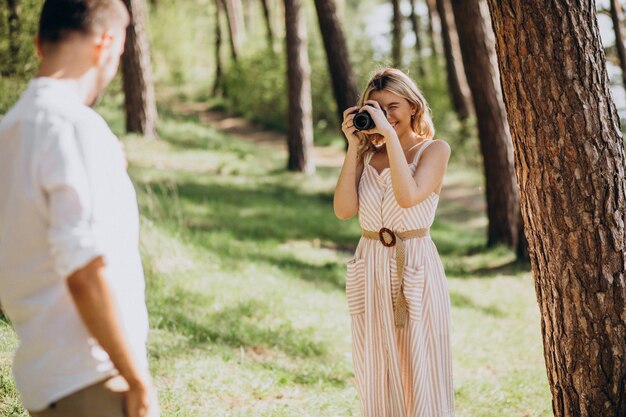 Pareja joven haciendo fotos en el bosque