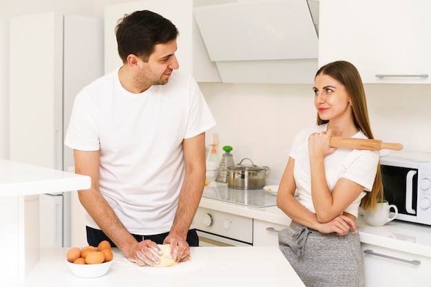 Pareja joven haciendo masa juntos