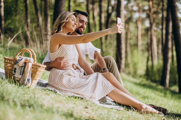 Pareja joven haciendo un picnic en el bosque