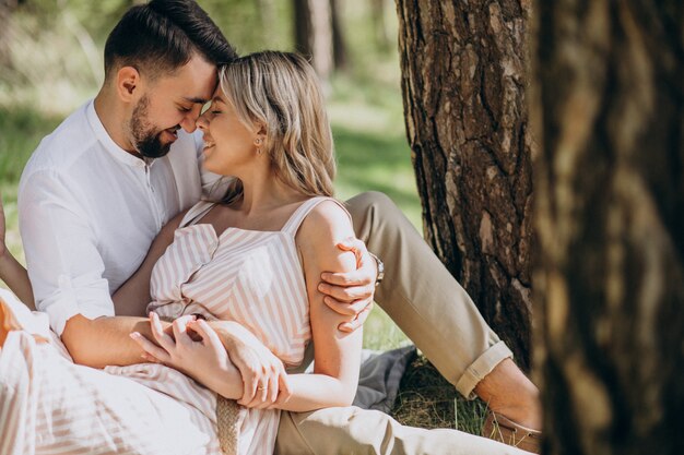 Pareja joven haciendo un picnic en el bosque