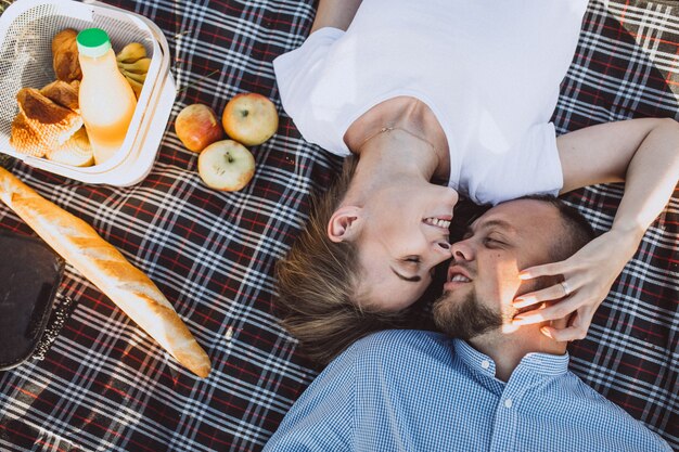 Pareja joven haciendo un picnic en el parque