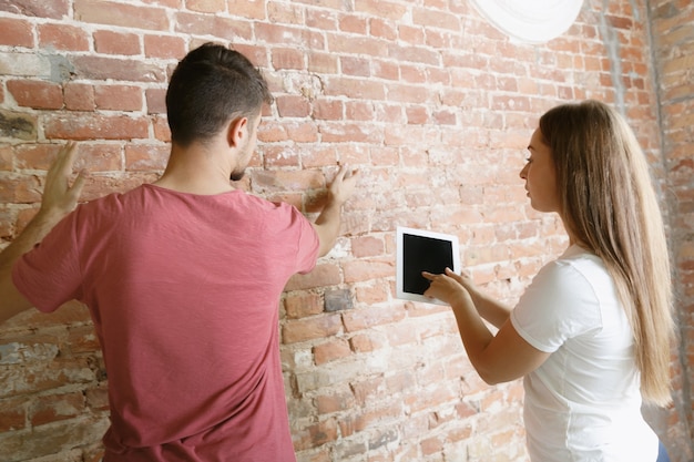 Foto gratuita pareja joven haciendo reparación de apartamentos juntos ellos mismos.