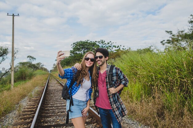 Pareja joven haciendo un selfie en vías de tren