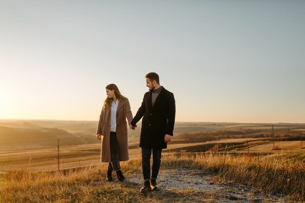 Pareja joven y hermosa caminando al aire libre en un día soleado