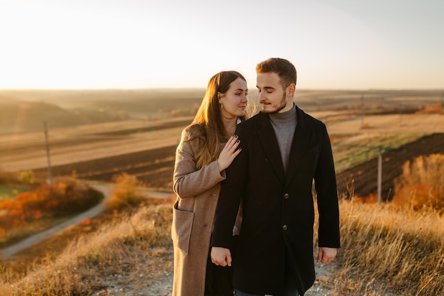 Pareja joven y hermosa caminando al aire libre en un día soleado