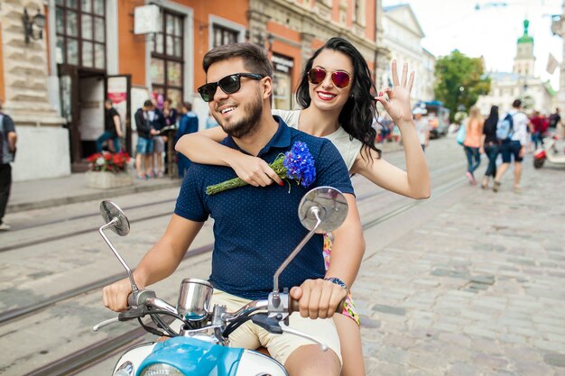 Pareja joven hermosa hipster montando en moto calle de la ciudad