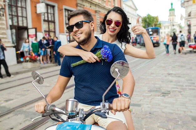 Pareja joven hermosa hipster montando en moto calle de la ciudad