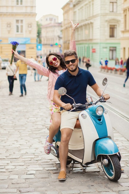 Pareja joven hermosa hipster montando en moto calle de la ciudad