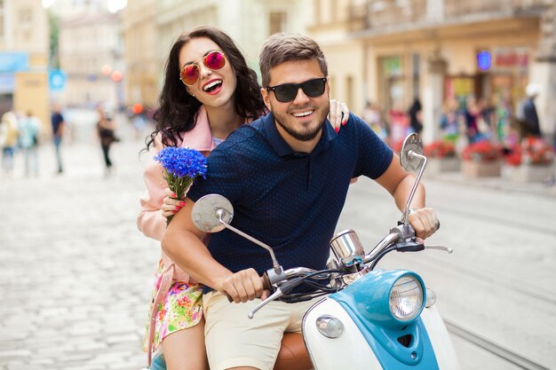 Pareja joven hermosa hipster montando en moto calle de la ciudad