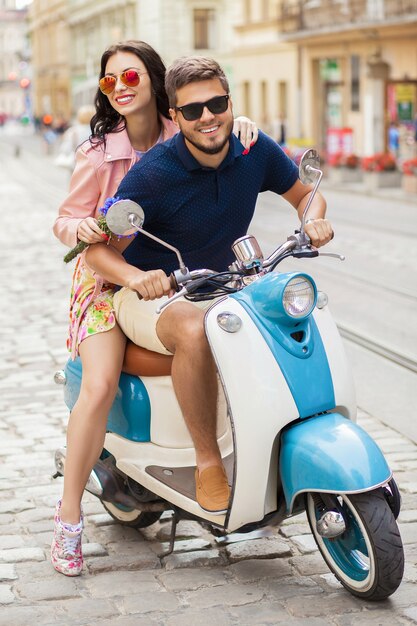 Pareja joven hermosa hipster montando en moto calle de la ciudad