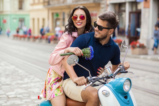 Pareja joven hermosa hipster montando en moto calle de la ciudad