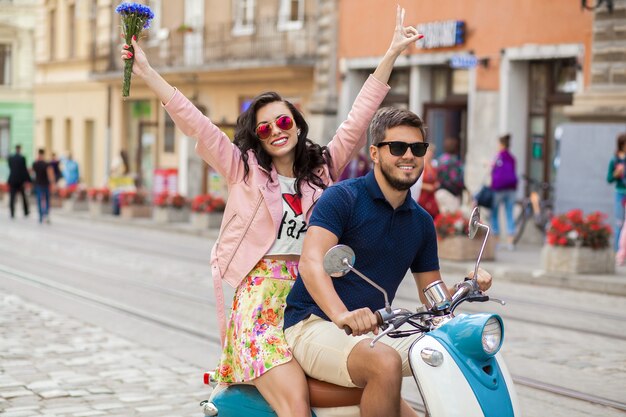 Pareja joven hermosa hipster montando en moto calle de la ciudad