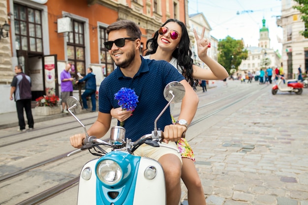 Pareja joven hermosa hipster montando en moto calle de la ciudad