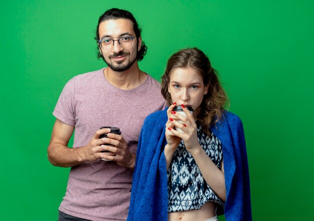 pareja joven, hombre y mujer, feliz, enamorado, tenencia, tazas de café, posición, encima, pared verde