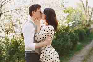 Foto gratuita pareja joven hombre y mujer en un jardín floreciente