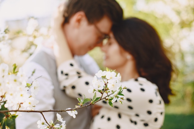 Pareja joven hombre y mujer en un jardín floreciente