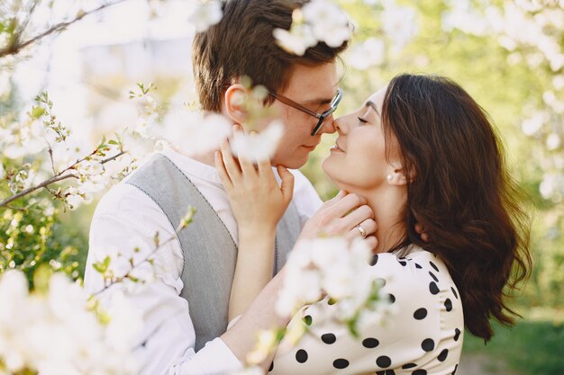 Pareja joven hombre y mujer en un jardín floreciente