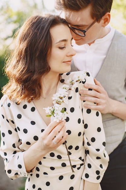 Pareja joven hombre y mujer en un jardín floreciente