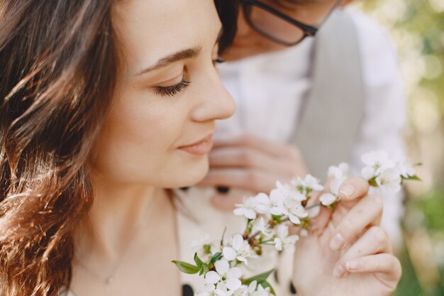 Pareja joven hombre y mujer en un jardín floreciente