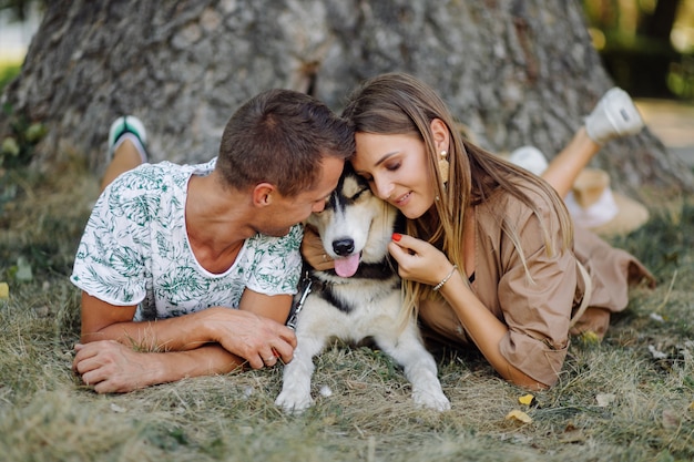 Foto gratuita pareja joven y husky