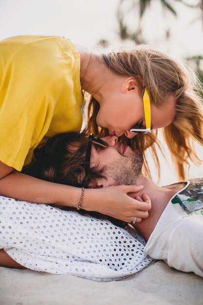 Pareja joven inconformista con estilo en el amor en la playa tropical durante la luna de miel de vacaciones, abrazo, encantador, romance, ternura, gafas de sol de estilo colorido