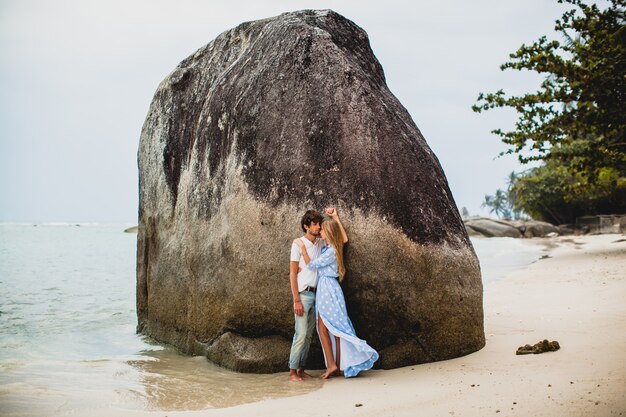 Pareja joven inconformista con estilo en el amor en la playa tropical durante las vacaciones